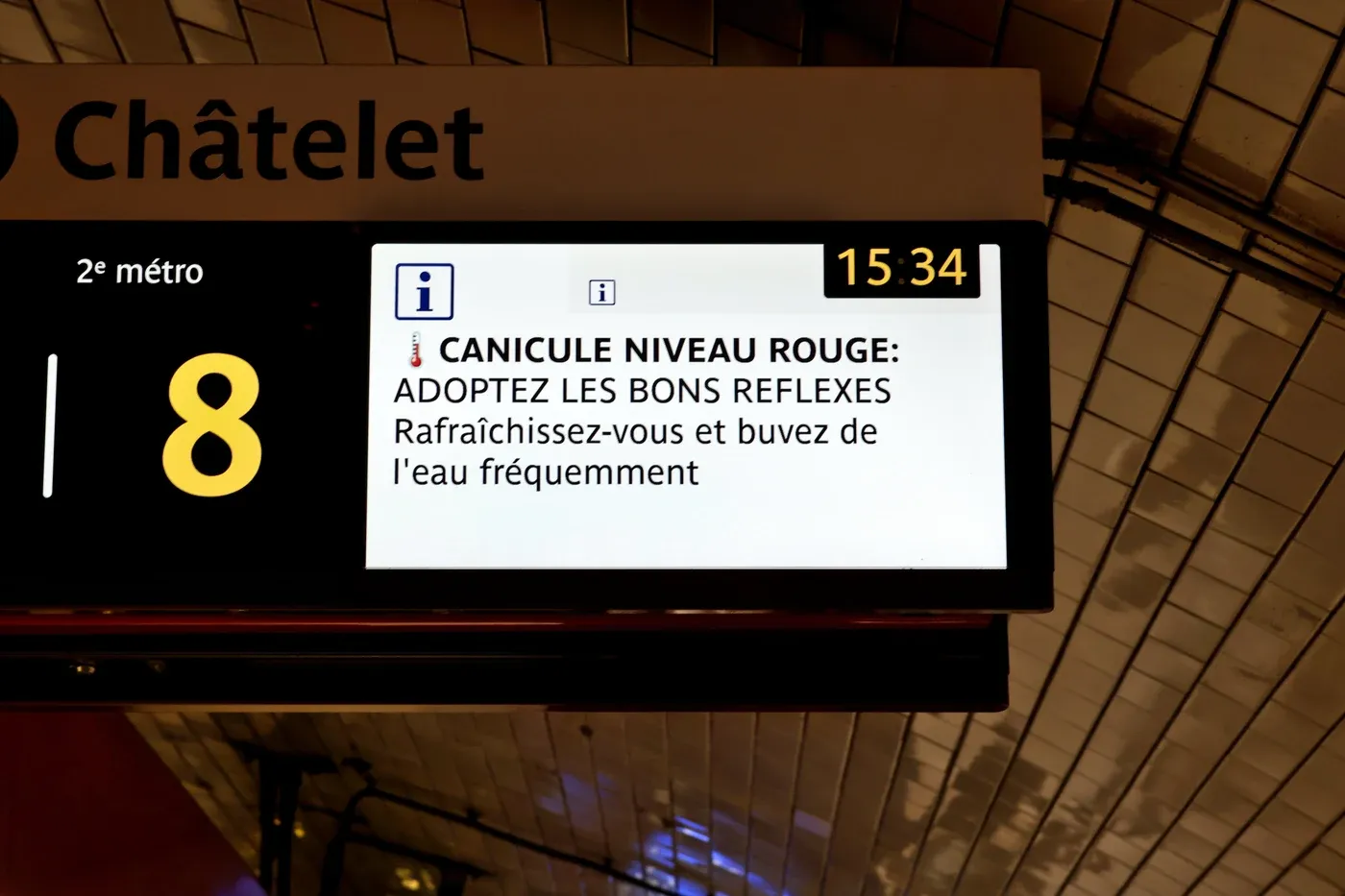 Écran d’affichage dans le métro parisien à la station Châtelet annonçant une alerte canicule niveau rouge