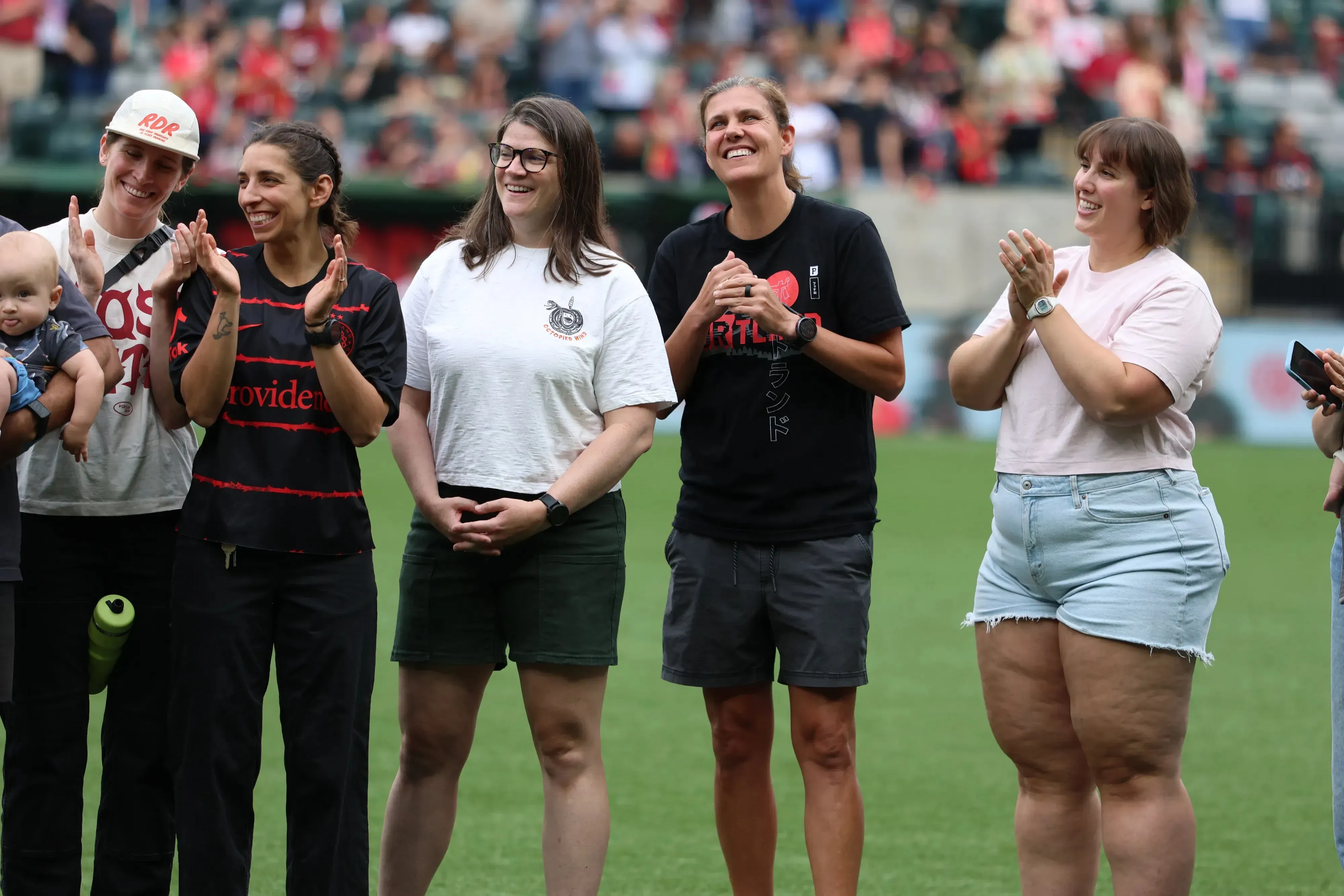 Christine Sinclair, entourée d’anciennes coéquipières, applaudie lors d’une cérémonie d’hommage sur la pelouse d’un stade de Portland