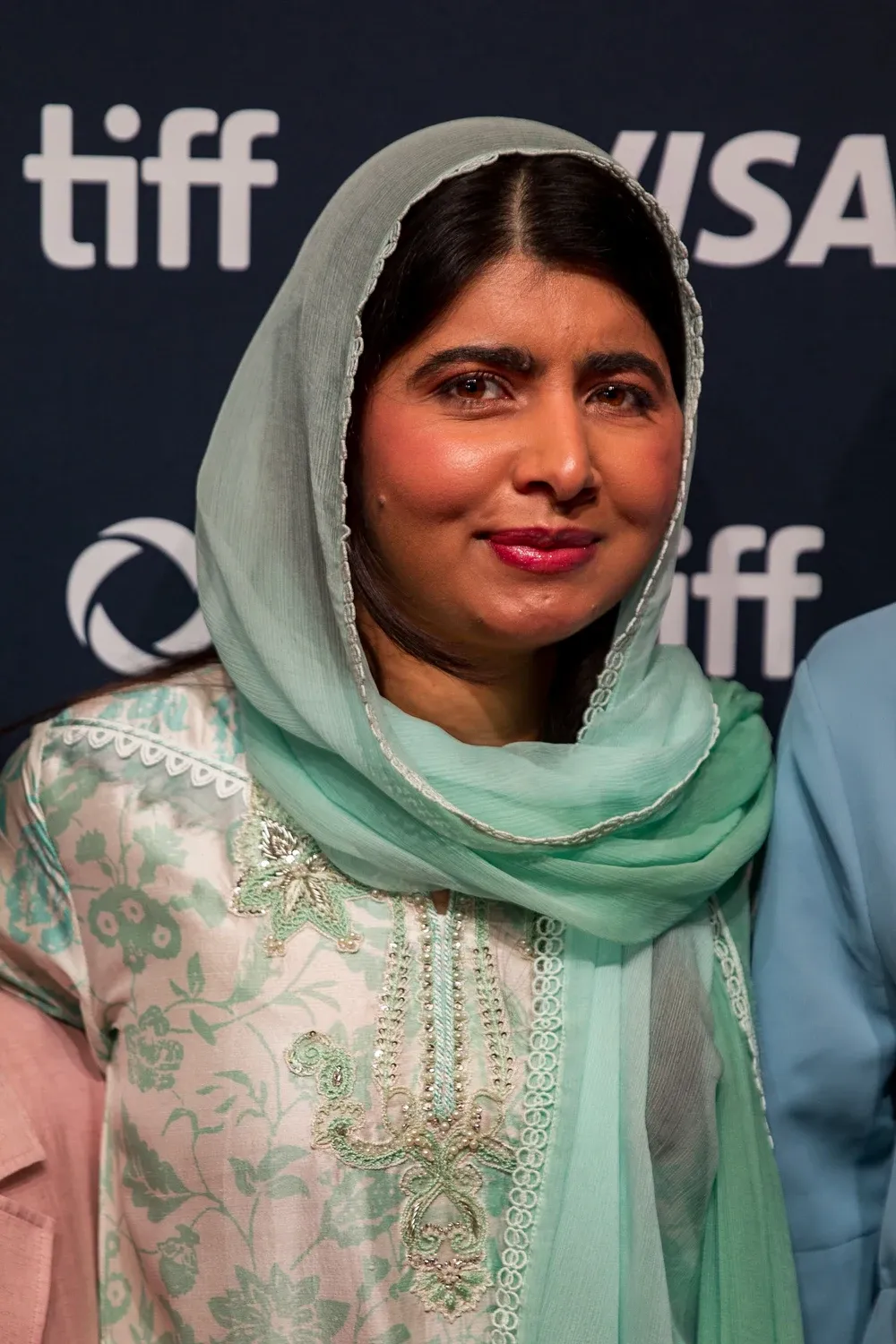 Portrait de Malala Yousafzai souriante, voile vert clair, lors d’un événement public