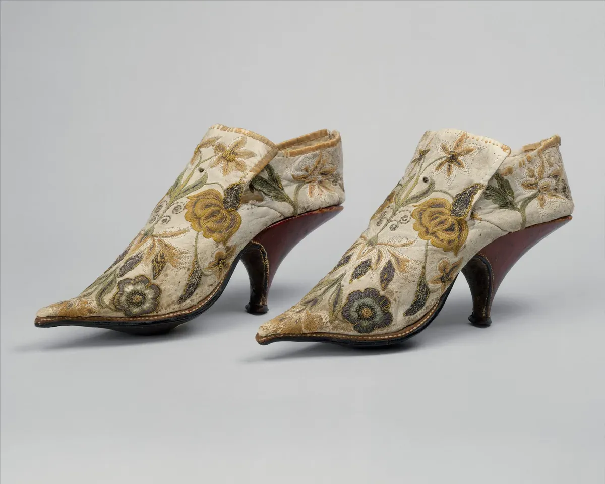 Paire de souliers français de la fin du XVIIe siècle en soie ivoire brodée de fleurs, bout pointu, talon cambré peint en rouge